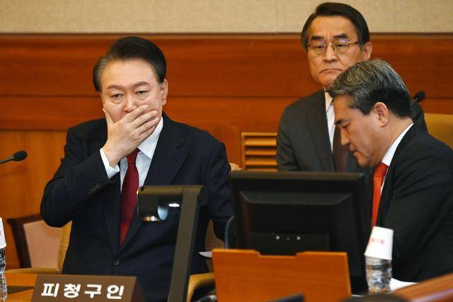 윤석열 대통령이 6일 서울 종로구 헌법재판소 대심판정에서 열린 탄핵 심판 6차 변론에 출석해 변호인과 대화하고 있다. 뉴시스