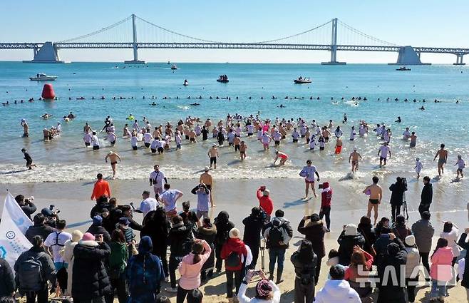 [부산=뉴시스] 하경민 기자 = '제38회 부산 북극곰 축제'가 열린 9일 부산 수영구 광안리해수욕장에서 시민과 관광객 등 인간 북극곰들이 차가운 겨울바다에 뛰어들고 있다. (사진=부산일보 제공) 2025.02.09. yulnetphoto@newsis.com *재판매 및 DB 금지