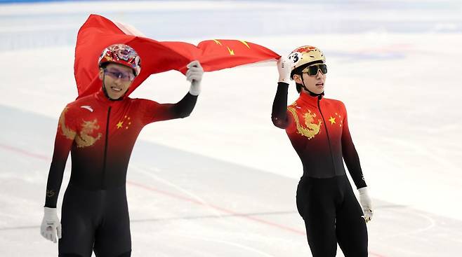 중국 하얼빈 헤이룽장 빙상훈련센터에서 열린 2025 하얼빈 겨울아시안게임 쇼트트랙 남자 500m 결승 경기에서 중국 린샤오쥔(오른쪽)이 금메달을 확정지은 뒤 4위 쑨룽과 함께 오성홍기를 들고 기뻐하고 있다. 2025.02.08. 뉴시스