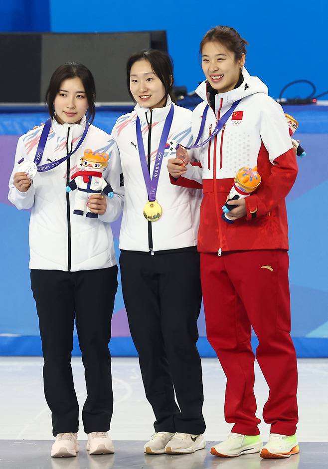 <yonhap photo-4017="">9일 중국 하얼빈 헤이룽장 빙상훈련센터 다목적홀에서 열린 하얼빈 동계아시안게임 쇼트트랙 여자 1,000m 시상식에서 금메달을 딴 최민정(가운데), 은메달 김길리, 동메달 중국 장추퉁이 메달을 목에 걸고 기념 촬영을 하고 있다. [연합뉴스]</yonhap>