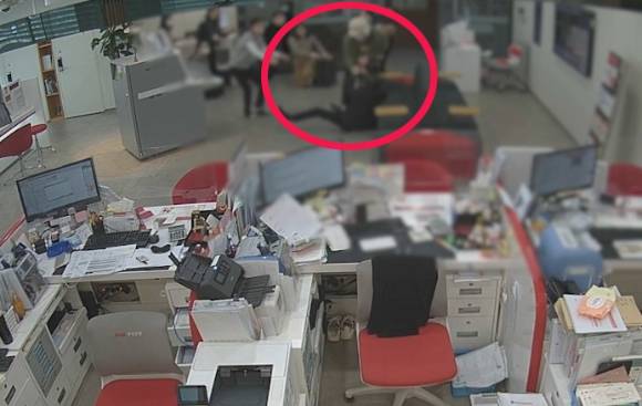 강도 손에 든 물건 빼앗는 용감한 시민. 사진 속 총기 추정 물체를 잡고 넘어져 있는 사람이 용감한 시민 박천규씨다 [사진=해당은행 제공/연합뉴스]