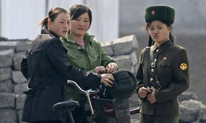 2010년 4월25일 북한 신의주 근처 압록강 기슭에서 북한 여군과 민간인이 서 있는 모습. 로이터연합뉴스