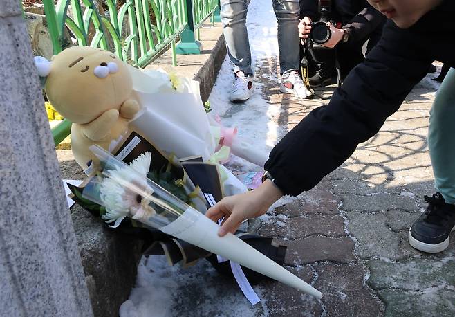 A child pays tribute in front of an elementary school in Daejeon's Seo-gu where an eight-year-old was stabbed allegedly by a teacher on Tuesday morning. (Yonhap)