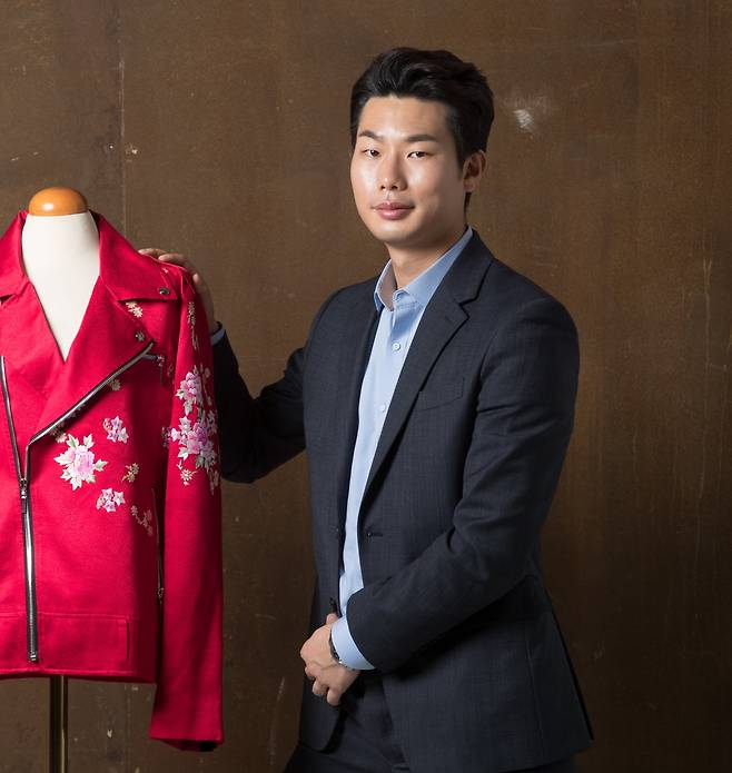 2021년 5월 조선일보와 인터뷰에서 김리을 디자이너가 미공개 한복 정장과 함께 포즈를 취하고 있다./고운호 기자