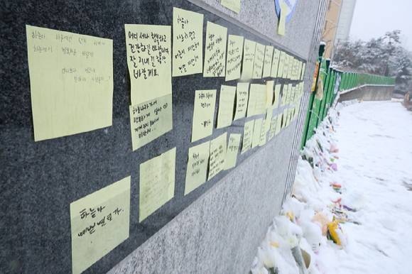 대전 초등학생 김하늘 양 피살사건이 발생한 대전 서구의 한 초등학교 정문에 12일 오전 시민들이 붙여놓은 쪽지와 꽃, 인형, 선물들이 가득 차 있다. [사진=연합뉴스]