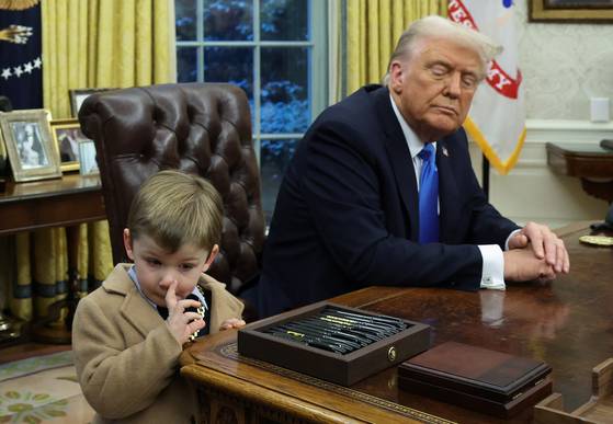 도널드 트럼프 미국 대통령(오른쪽)이 11일(현지시간) 백악관 집무실에서 질의응답을 하던 중 자신의 곁에서 코를 만지는 머스크의 아들 엑스를 쳐다보고 있다. 로이터=연합뉴스