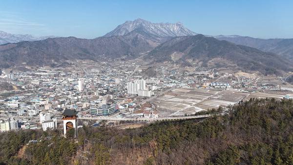 경북 문경 석화산에서 드론을 날려 보내 찍은 조망이다. 봉명산 능선에 4층 높이의 망대를 세워 석화산과 연결한 출렁다리 뒤로 흰눈을 이고 선 문경의 진산인 주흘산이 울퉁불퉁한 공룡 등뼈의 모습을 드러낸다. 그 가운데 문경읍 전경이 펼쳐진다.
