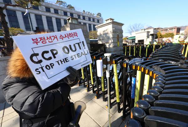 ▲지난 3일 오후 서울 종로구 헌법재판소 앞에서 윤석열 대통령 지지자가 '부정선거 수사하라'는 구호가 적힌 피켓을 들고 있는 모습. ⓒ연합뉴스