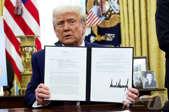 도널드 트럼프 미국 대통령이 13일(현지시간) 미국 워싱턴DC 백악관 오벌 오피스에서 '상호관세'에 관한 메모에 서명한 뒤 이를 들어 보이고 있다. ⓒ 로이터=뉴스1 ⓒ News1 류정민 특파원