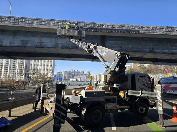 경기남부도로 직원들이 고소차 크레인을 동원해 떨어져 나간 콘크리트 잔해물을 제거하고 있다. 의왕경찰서 제공
