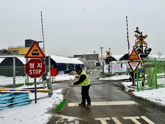 눈이 내린 지난 12일 대곡역 인근 철도 건널목에서 안전요원 김영호씨가 눈을 쓸고 있다. 이 건널목은 여전히 통행이 가능하지만, 기존 건널목을 울타리로 막아 주민 민원이 발생하기도 한다. 김씨는 "그래도 불편보다는 안전이 우선"이라고 말했다. 김홍준 기자