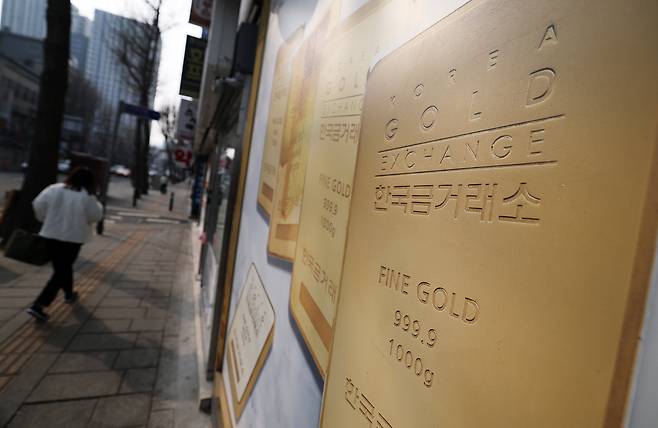 금 현물시장 'KRX 금시장'의 시장가가 국제 금 시세보다 비싼 상태가 계속되는 등 금 투자 수요가 폭증하는 가운데 16일 서울 종로구 한국금거래소 외벽에 부착된 골드바 사진 앞으로 시민이 지나가고 있다. /뉴스1