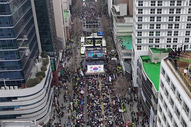 15일 오후 광주 동구 금남로에서 경찰버스로 만든 차벽을 사이에 두고 윤석열 대통령 탄핵에 찬성(아래쪽), 반대(위쪽)하는 집회가 각각 열리고 있다. 연합뉴스