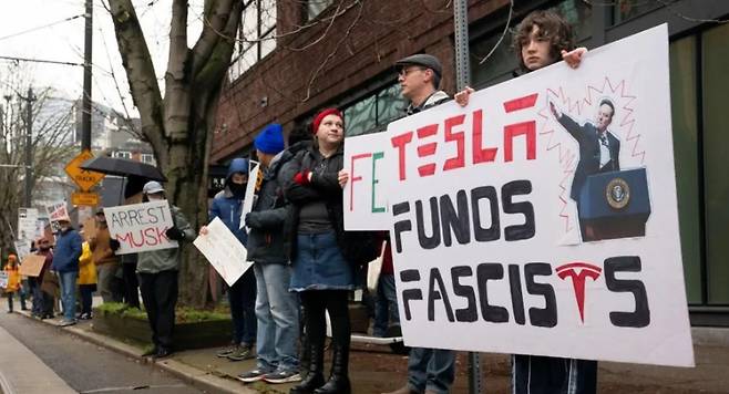 15일(현지시간) 미국 시애틀의 테슬라 매장 인근에서 일론 머스크 CEO를 반대하는 시위가 벌어졌다. /로이터=뉴스1