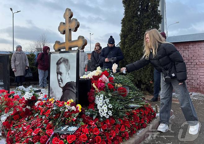 16일(현지시간) 러시아 모스크바 보리솝스코예 묘지에 있는 알렉세이 나발니의 묘지에서 시민들이 나발니 사망1주기를 추모하고 있다.  ⓒ 로이터=뉴스1