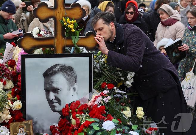 16일(현지시간) 러시아 모스크바 보리솝스코예 묘지에 있는 알렉세이 나발니의 묘지에서 시민들이 나발니 사망1주기를 추모하고 있다.  ⓒ 로이터=뉴스1