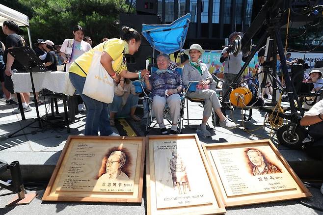 세계 일본군 위안부 기림일이자 74주년 광복절을 하루 앞둔 2019년 8월14일 오후 서울 종로 옛 주한일본대사관 앞에서 열린 1400차 일본군 성노예제 문제해결을 위한 정기 수요집회 길원옥 할머니가 세월호 참사 희생자 가족과 인사하고 있다. 박종식 기자 anaki@hani.co.kr
