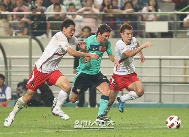 "FC바르셀로나 초청 K리그올스타전서 바르셀로나 메시(가운데)가 올스타 김형일 최효진사이에서 문전으로 볼을 드리블하고있다. 2010.08.04 상암=정시종기자