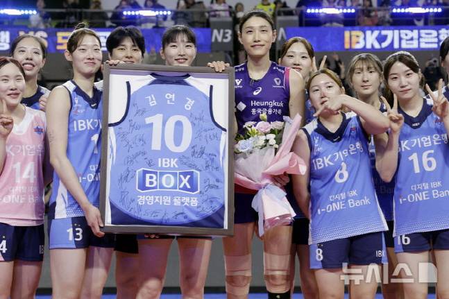 김연경(왼쪽에서 6번째)이 IBK기업은행 선수단이 준비한 친필사인 유니폼 액자를 들고 함께 기념촬영을 하고 있다. /사진=뉴시스