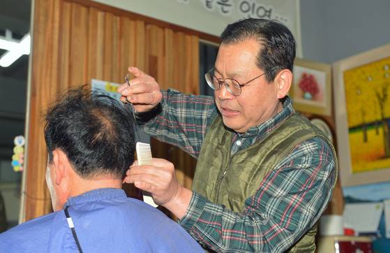 이좌수(68)씨가 형제이용원에서 손님 머리를 다듬고 있다. 김성태 객원기자