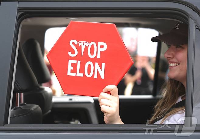 17일(현지시간) 대통령의 날을 맞아 캘리포니아주 노스 할리우드에서 도널드 트럼프 대통령과 일론 머스크 졍부효율부 장관에 반대하는 시위가 열리고 있다. 한 시민이 '스톱 머스크'라는 팻말을 들고 있다. ⓒ AFP=뉴스1 ⓒ News1 우동명 기자