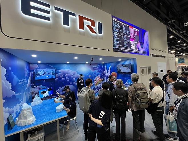 지난 2023 독일 IFA ETRI 전시 부스에서 ETRI 연구진이 다중참여 원격몰입 XR기술을 시연하고 있다.[ETRI 제공]