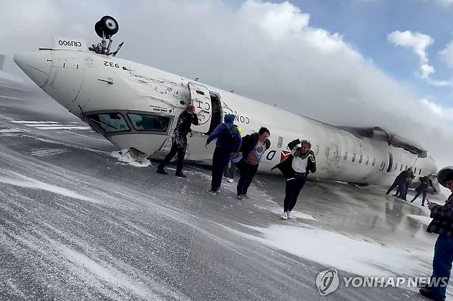 지난 17일(현지시간) 토론토 공항의 전복된 여객기에서 탈출하는 승객들 [토론토 로이터=연합뉴스. 재판매 및 DB 금지]