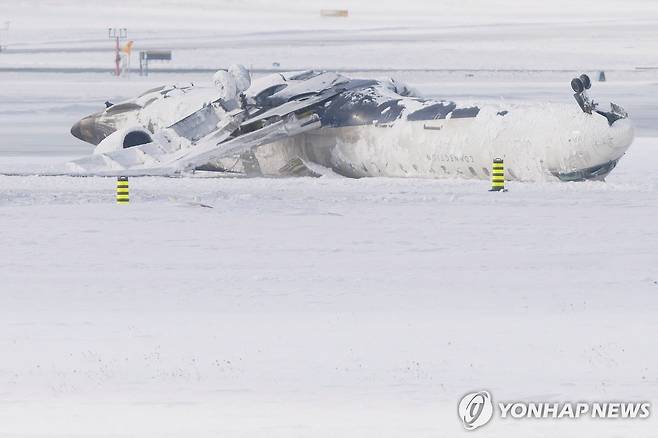 18일 토론토 공항 활주로에 뒤집혀 있는 델타항공 여객기 [토론토 로이터=연합뉴스. 재판매 및 DB 금지]