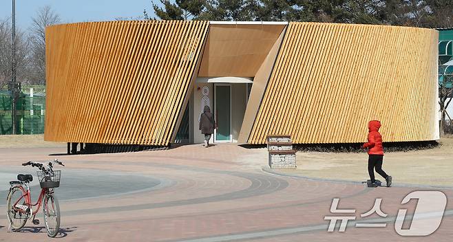 대구 수성구 수성못 상화동산 공중화장실이 최근 리모델링 공사를 마치고 개방됐다. 스페인 건축가의 설계를 바탕으로 예술적 요소를 강조한 이 화장실 리모델링 공사에 수성구가 예산 9억 원을 투입한 사실이 알려지며 논란이 일고 있다. 20일 수성못을 찾은 시민들이 화장실을 이용하고 있다. 2025.2.20/뉴스1 ⓒ News1 공정식 기자