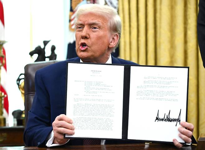 도널드 트럼프 미국 대통령은 수치로 나타나는 관세율 뿐 아니라 비관세 장벽까지 관세율 계산 때 포함하는 방식으로 무역 상대국을 압박하고 있다. 사진은 지난 2월 13일 상호관세 계획 행정명령을 들어보이고 있는 모습./AFP 연합뉴스