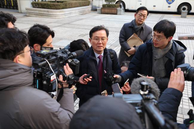 윤석열 대통령 변호인단 윤갑근 변호사가 20일 오전 서울 서초구 서울중앙지법에서 열리는 윤 대통령의 내란 우두머리 혐의 첫 형사재판에 참석하기 위해 법원에 들어서며 취재진의 질문에 답하고 있다.  사진공동취재단