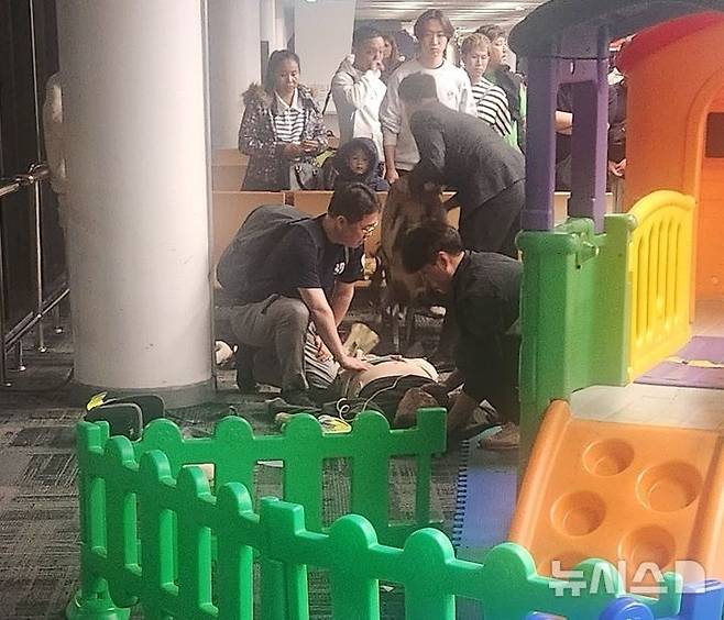 [용인=뉴시스] 태국 공항에서 응급처치 중인 은성용(오른쪽) 소방교와 최일국 교수. (사진=용인소방서 제공) 2025.02.20. photo@newsis.com