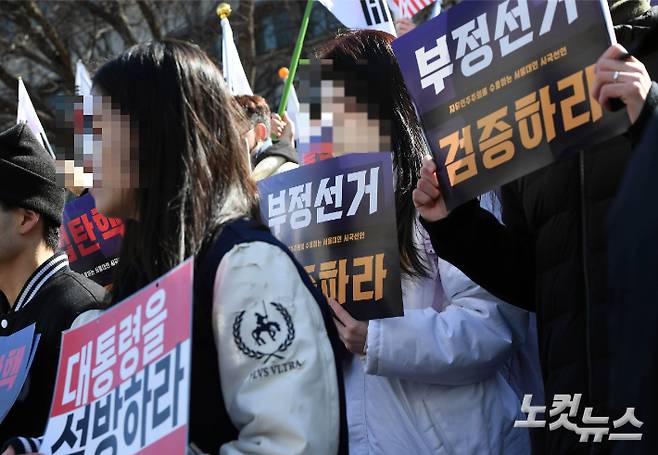 17일 오전 서울 관악구 서울대 아크로폴리스 광장에서 자유민주주의를 수호하는 서울대인 주최로 열린 '탄핵반대 시국선언' 에서 '불법탄핵 각하하라' 손피켓을 들고 있다. 황진환 기자