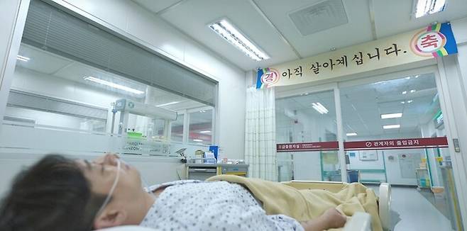 ‘중증외상센터’ 8회. 백강혁이 화재현장에서 뜨거운 금속이 간에 박히는 외상을 입지만, 제자 양재원의 수술 성공으로 거뜬히 깨어나는 장면. 넷플릭스 제공