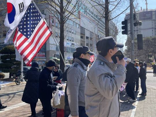 이날 윤석열 대통령 탄핵 반대 집회 '세이브코리아 국가비상기도회'가 열린 대전시청 남문광장 앞에서 태극기를 판매하는 시민들 사이로 경찰들이 지나가고 있다. 최다인 기자