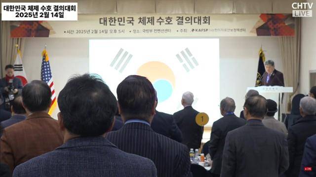 14일 서울 용산 국방컨벤션에서 한미자유안보정책센터 주최로 열린 '대한민국 체제 수호 결의대회'에서 참석자들이 국민의례를 하고 있다. CHTV 유튜브 캡처