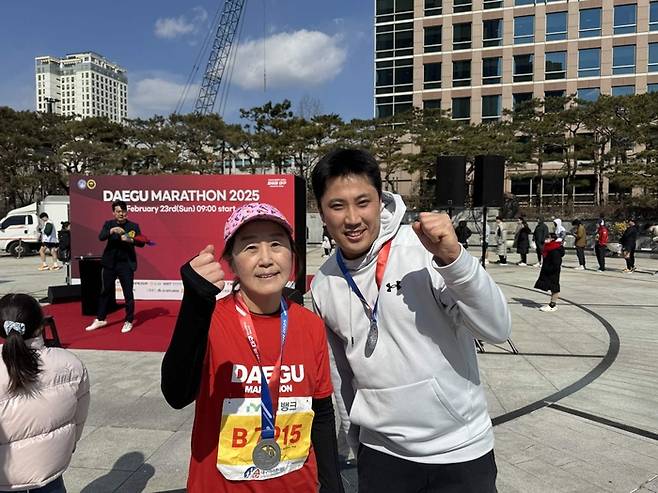 김미경 서울대 의대 교수가 23일 대구 수성구 대구스타디움에서 열린 ‘2025 대구마라톤’에 참석해 시민과 사진을 찍고 있다. [사진출처=안철수 의원실]