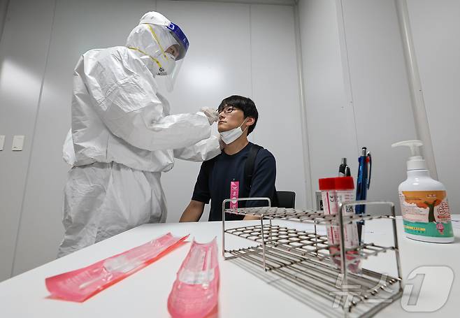 3일 인천국제공항 제2여객터미널에서 열린 ‘수도권 해외유입 신종감염병 대응 합동훈련'에서 임상증상 자진신고 승객을 가정한 훈련 참가자가 검체 채취를 하고 있다. 2024.9.3/뉴스1 ⓒ News1 김도우 기자