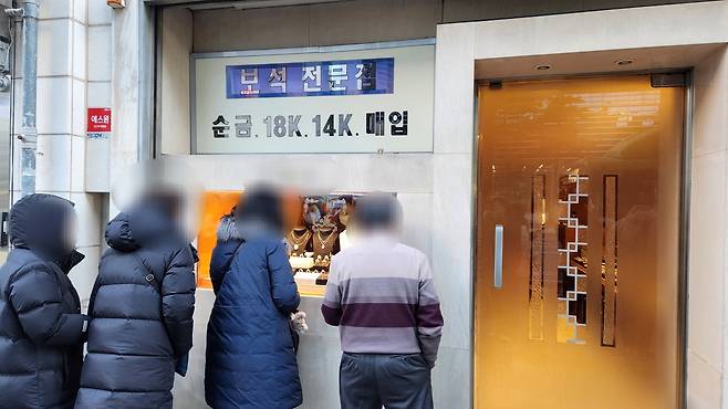 서울 중구에 위치한 한 금은방 앞에서 사람들이 금을 구경하고 있다. [정호원 기자]