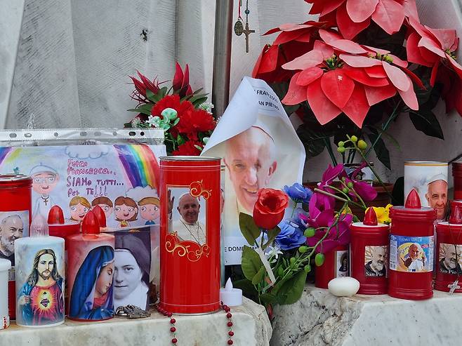 24일 제멜리 병원 앞의 요한 바오로 2세 석상 앞에 프란치스코 교황의 무사 회복을 기원하는 초와 꽃들이 놓여 있다. /바티칸=정철환 특파원