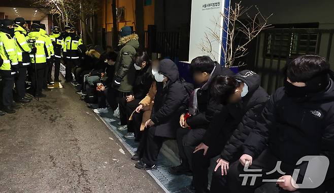 내란 우두머리 혐의로 체포된 윤석열 대통령의 영장실질심사가 열린 18일 오후 서울 마포구 서울서부지방법원에서 윤 대통령의 석방을 촉구하며 법원 담장을 넘어 들어온 청년들이 경찰에 붙잡혀 있다.(공동취재) 2025.1.19/뉴스1 ⓒ News1 민경석 기자