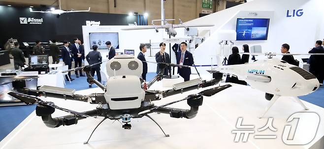 26일 부산 해운대구 벡스코 제1전시장에서 열린 'DSK 2025(드론쇼코리아)'에서 관람객들이 LIG넥스원부스에 전시된 하이브리드 수송드론 다목적 무인헬기 등 다양한 드론을 살펴보고 있다. 오는 28일까지 열리는 이번 행사에는 역대 최대인 15개국, 306개 사가 1130 부스 규모로 참가하는 전시회와 콘퍼런스, 다양한 체험 이벤트 등으로 구성된다. 2025.2.26/뉴스1 ⓒ News1 윤일지 기자