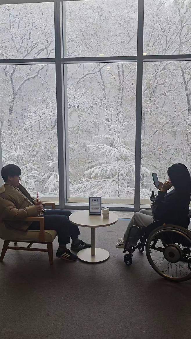 Jeon Byung-ju (left) and Kim Hye-mi take in the view from the lobby of their Samsung Electronics office building. (Kim Hye-mi)