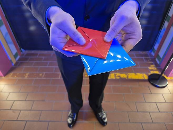 26일 서울 성동구 성수동 에스팩토리에 마련된 ‘오징어게임 : 더 익스피리언스’에서 만난 ‘딱지맨’이 기자에게 딱지를 내밀고 있다. 김동환 기자