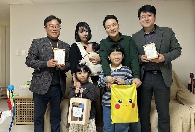 엘앤에프 관계자(왼쪽 끝, 오른쪽 끝)가 임직원 자녀에게 초등학교 입학 축하 선물을 전달하고 있다. 사진제공=엘앤에프