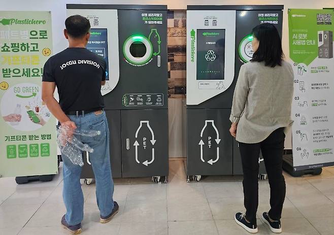 에코센트레가 설치, 운영하고 있는 폐플라스틱 자원순환 리사이클 플랫폼 서비스인 플라스틱히어로 AI로봇을 찾은 소비자들이 페트병을 넣고 있다.