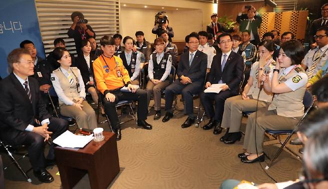 문재인 대통령이 2017년 5월 12일 인천공항공사에서 열린 ‘찾아가는 대통령, 공공부문 비정규직 제로시대를 열겠습니다!’ 행사에 참석해 비정규직 문제 해결을 건의하며 눈물을 닦는 참석자를 보고 있다. [뉴시스]