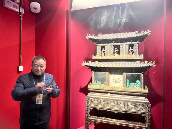 궈푸샹 궁정역사부 수석위원이 지난 21일 자금성 시계전시실에서 청 황실이 직접 제작한 ‘채칠묘금자개문군선시수루각식종(彩漆描金自開門群仙視壽樓閣式鐘)’을 소개하며 중서 문화 교류의 대표적 작품이라고 설명하고 있다. 신경진 기자