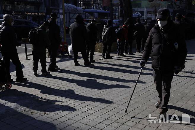 [서울=뉴시스] 최동준 기자 = 24일 서울 종로구 탑골공원 앞 무료도시락 배급 봉사단 앞으로 어르신들이 줄을 서고 있다. 2024.12.24. photocdj@newsis.com