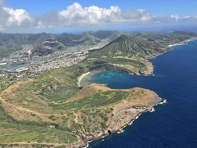 하와이주 오하우섬 동쪽 땅끝마을 마카푸 포인트는 말발굽 모양의 만 남쪽에 있고 그 안쪽으로 멀리 한반도 마을 일부가 보인다.[헤럴드경제 함영훈기자 헬기 촬영]